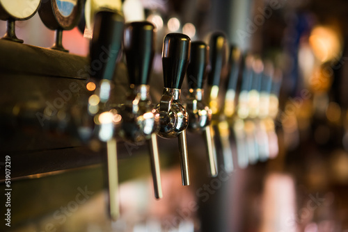 Close up image of beer taps at pub.
