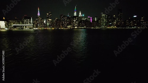 Wallpaper Mural An  aerial view of Manhattan from over the East River in NY. It was taken on a quiet night with clear skies. The drone camera dolly in over an illuminated structure flying towards the city. Torontodigital.ca