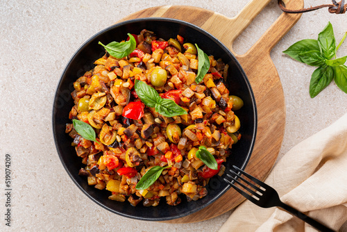 Overhead view of Caponata siciliana - Italian, Sicilian stew consisting of chopped fried aubergine or eggplant and other  vegetables like celery, olives, bell pepper, tomato and toasted pine nuts. 
