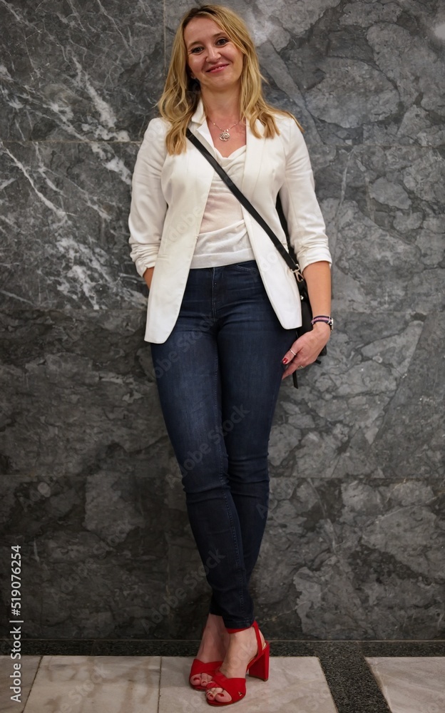 Beautiful blond mature woman standing against the wall Beautiful blond mature woman standing against the wall
