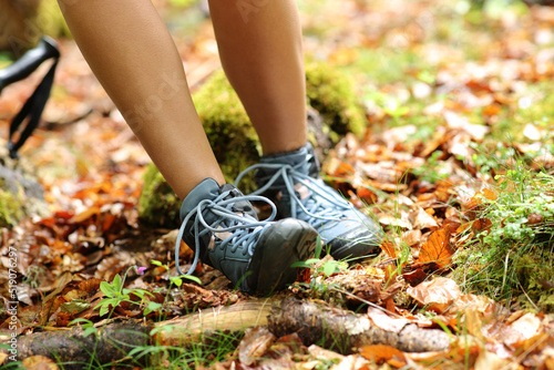 Trekker stumbling suffering sprain on ankle in a forest photo