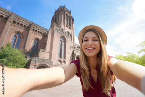 Beautiful young woman taking selfie photo in front of Liverpool Cathedral in England, UK photo