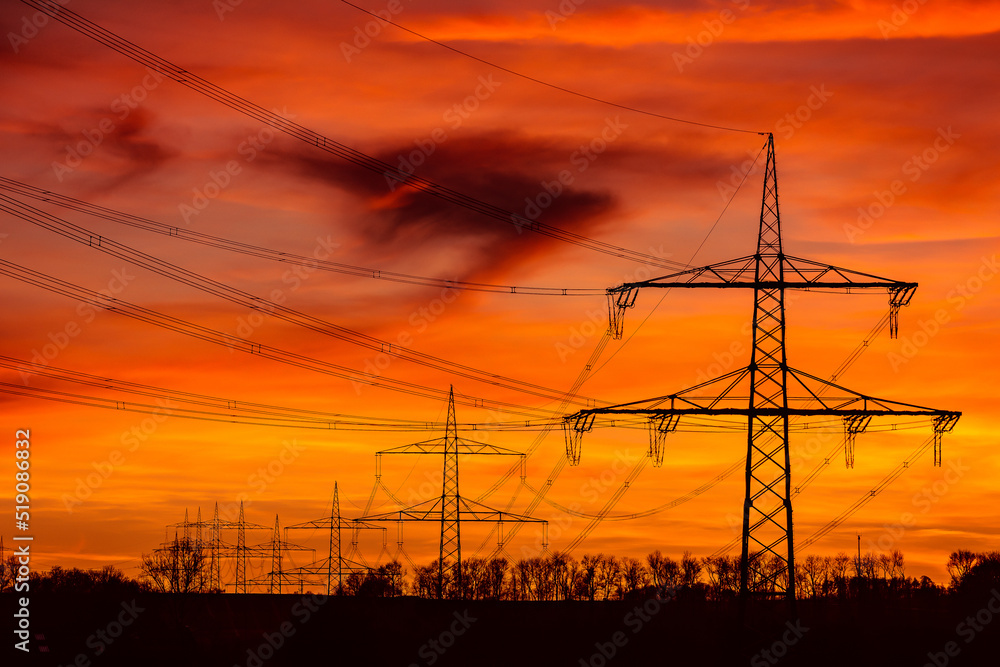 Fototapeta premium Power grid High power electricity poles in the sunset. Energy supply, distribution of energy, transmitting energy, energy transmission, high voltage supply.