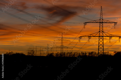 Power grid High power electricity poles in the sunset. Energy supply, distribution of energy, transmitting energy, energy transmission, high voltage supply.