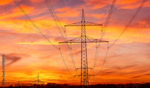 Power grid High power electricity poles in the sunset. Energy supply, distribution of energy, transmitting energy, energy transmission, high voltage supply.