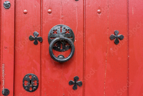 Tableau sur toile Porte en bois peinte en rouge ancienne avec un heurtoir rond