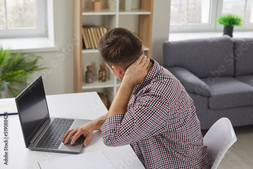 Bild auf Leinwand Man feels neck pain after working on laptop