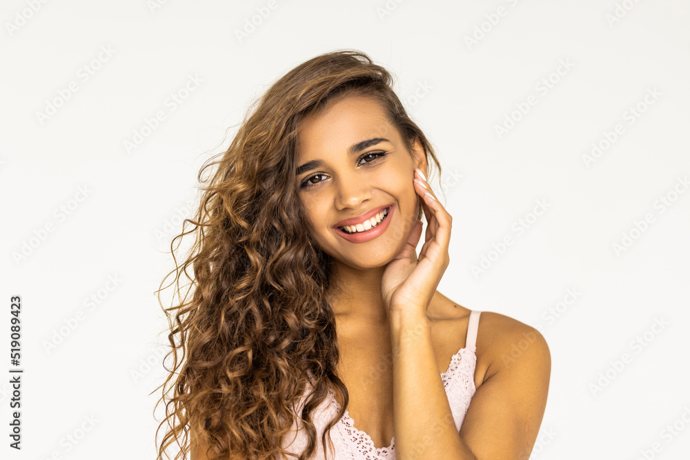 Fototapeta premium Beauty portrait of young attractive woman with toothy smile. Long curly hair. Girl looking at camera. White background.