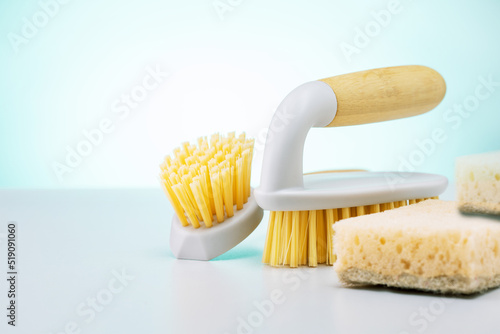 Eco brushes and sponges on light green background. Flat lay eco cleaning products.