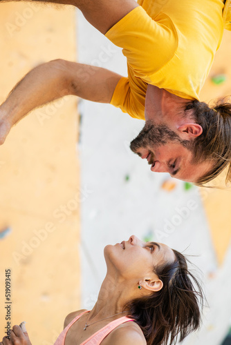 Man and woman on the background of an artificial climbing wall.