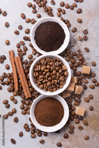 Roasted beans and different ground coffee with cinnamon and sugar for morning espresso