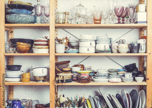 Shelves with kitchen clutter, utensils and kitchenware