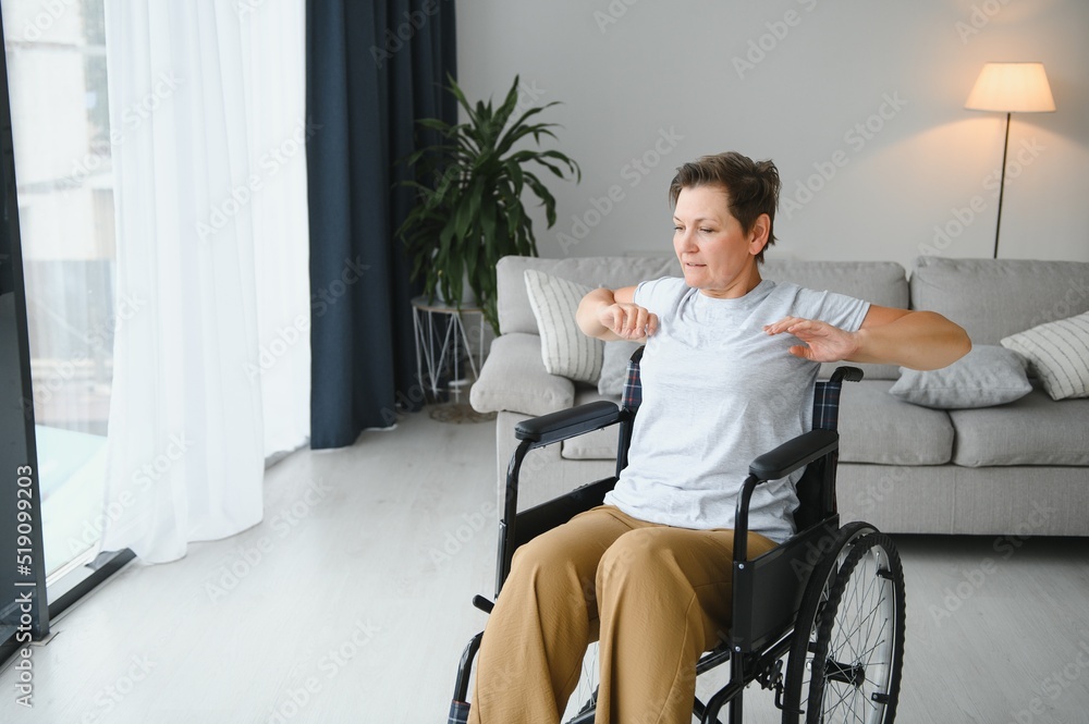 Woman in wheelchair working out in living room