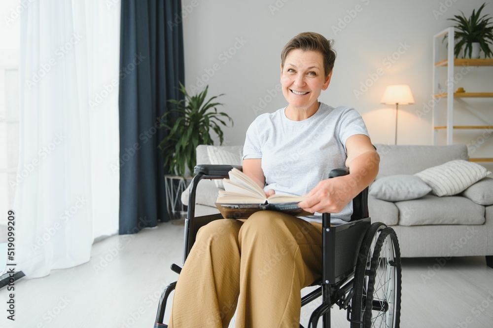 Shot of a senior woman sitting in a wheelchair and reading book at home Shot of a senior woman sitting in a wheelchair and reading book at home