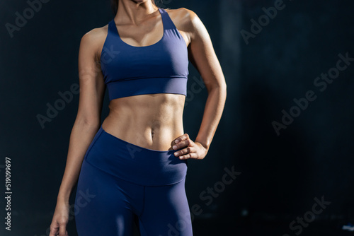 Close up Asian abs sportswoman in sportwear exercising in fitness club
