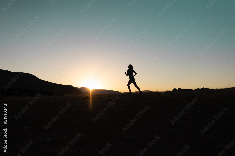 girl runs at sunset in the mountains.