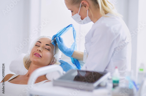 Permanent makeup for eyebrows. Closeup of beautiful woman with thick brows in beauty salon.