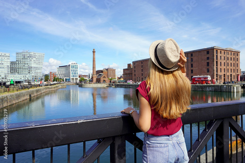 Tourism in Liverpool, UK. Back view of traveler girl on Swing Bridge visiting the Royal Albert Dock in Liverpool, England. photo