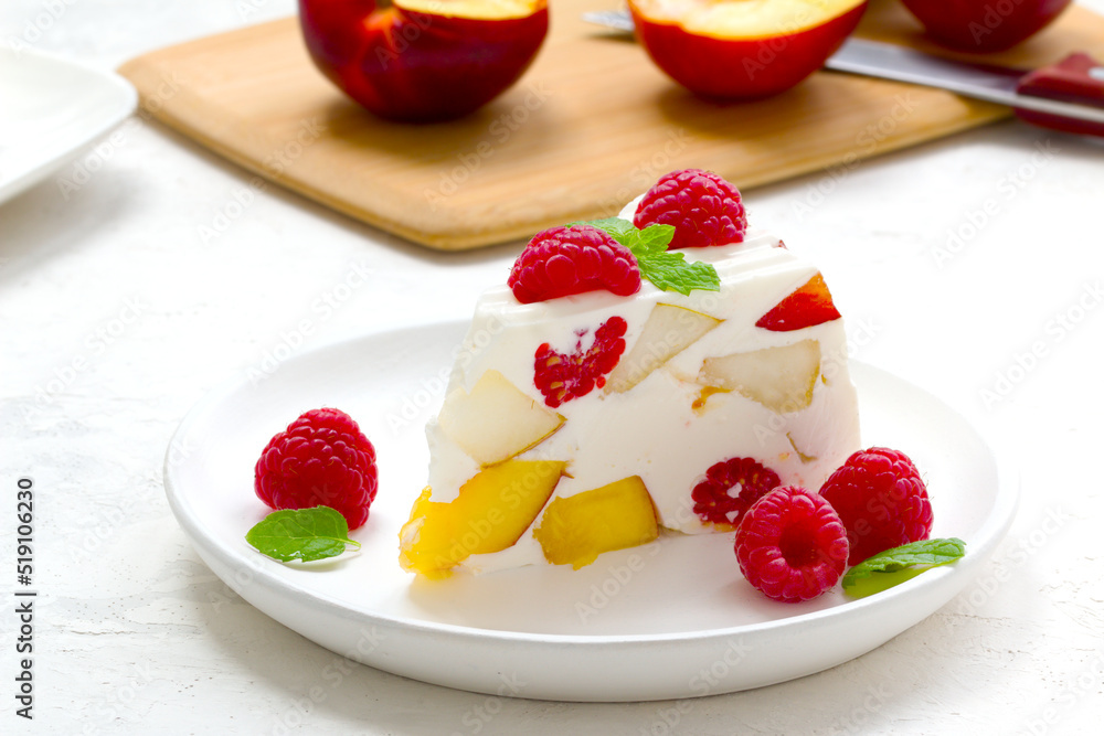 fruit dessert. ice cream with pieces of fruit and ripe raspberries on a white dish fruit dessert. ice cream with pieces of fruit and ripe raspberries on a white dish