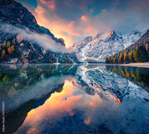 First snow on Braies Lake. Foggy autumn view of Italian Alps, Naturpark Fanes-Sennes-Prags. Picturesque sunrise in DolomiteAlps, Italy, Europe. Beauty of nature concept background.