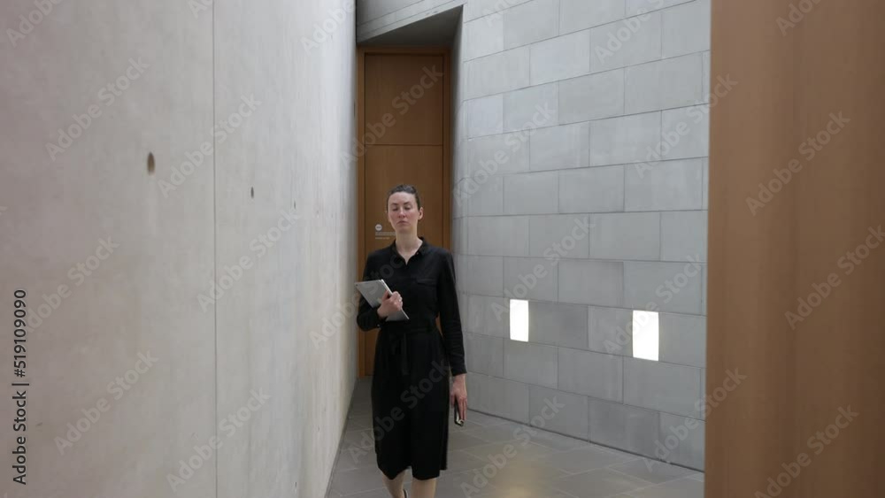 Businesswoman walking indoors holding tablet pc Businesswoman walking indoors holding tablet pc