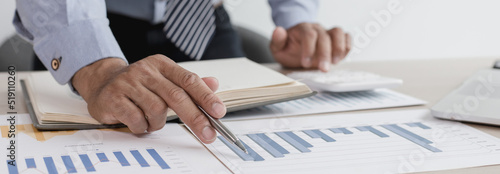 Business men analyze financial graphs and find break-even points for investments in order to reduce costs and reduce corporate taxes, Analysis of financial accounting and real estate investment.