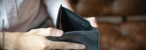 Young man had no money in his wallet, save money concept.