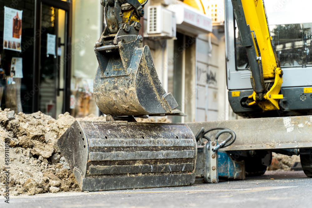 Fototapeta premium A bulldozer on the street digging a hole