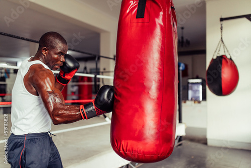 Muscular African boxer practicing his punches photo