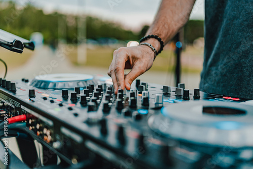 DJ Hands creating and regulating music on dj console mixer in concert outdoor