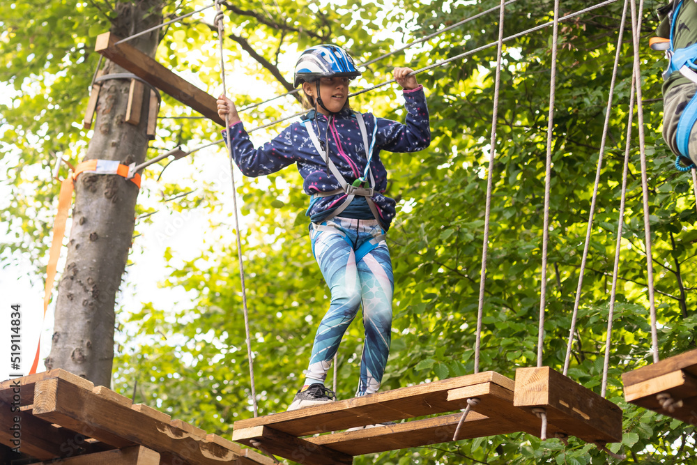 Adorable little girl enjoying her time in climbing adventure park on warm and sunny summer day. Adorable little girl enjoying her time in climbing adventure park on warm and sunny summer day.
