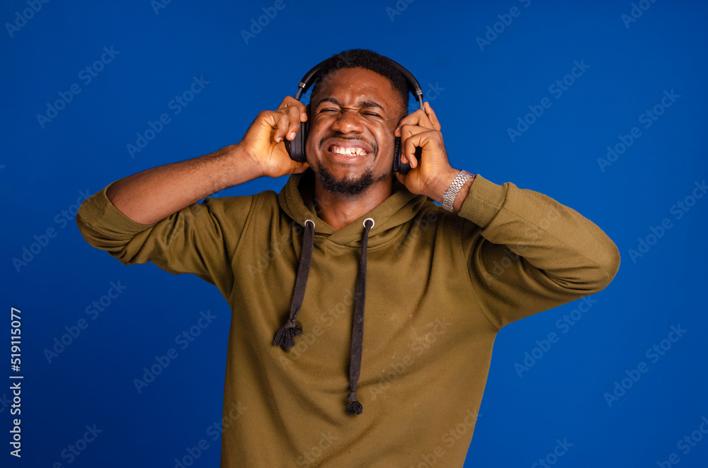 Naklejka premium African American man with headphones on blue background