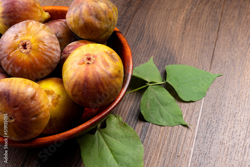 Freshly ripe figs. Healthy Mediterranean fig fruit. Fresh figs on a dark background. Beautiful blue violet figs with leaves, copy space, closeup