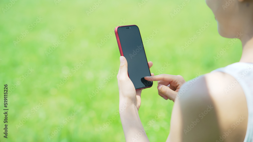 屋外でスマートフォンを使う女性