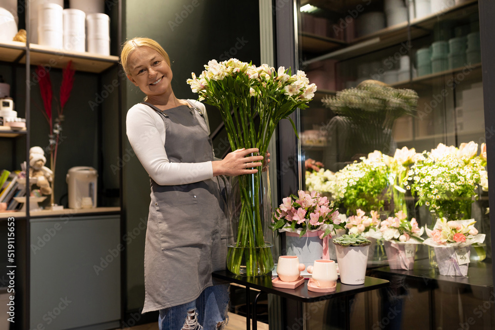 an employee of a floristic boutique holding fresh flowers in his hands