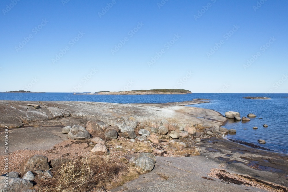 Rocky seashore in sunny weather in spring on the island of Ulko-Tammio, Eastern Gulf of Finland National Park, Finland. Rocky seashore in sunny weather in spring on the island of Ulko-Tammio, Eastern Gulf of Finland National Park, Finland.