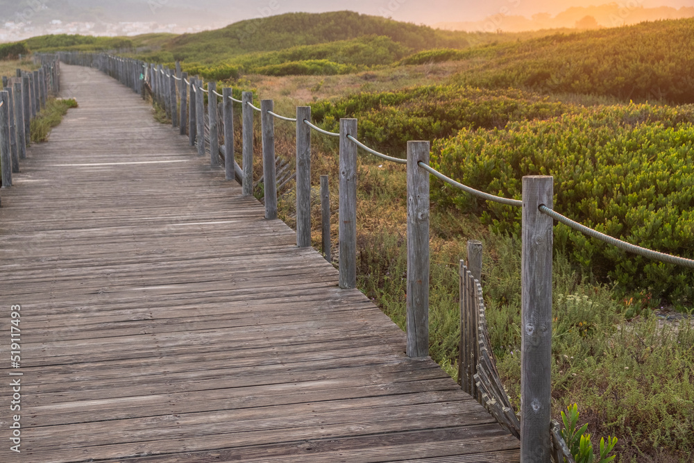 selective focus wooden path to the beach on the dunes at sunrise, northern Portugal