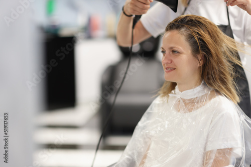 Hair styling process in beauty salon with hair dryer