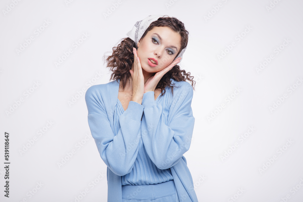 High fashion photo of a beautiful elegant young woman in a pretty blue suit, pants, top, cardigan white sneakers, head scarf posing over white background. Studio Shot. Portrait High fashion photo of a beautiful elegant young woman in a pretty blue suit, pants, top, cardigan white sneakers, head scarf posing over white background. Studio Shot. Portrait