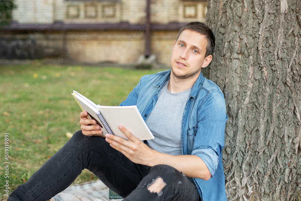 Young man relaxing and reading book while sit on lawn. Happy Man sitting On Green Grass and study remotely. Adult student reading in the park. Enjoying student life. smiling man working on outdoor
Young man relaxing and reading book while sit on lawn. Happy Man sitting On Green Grass and study remotely. Adult student reading in the park. Enjoying student life. smiling man working on outdoor