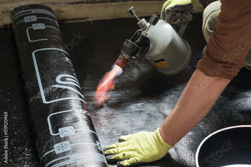 Φωτογραφία installation of waterproofing coating on the floor with a blowtorch and resin