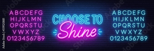 Choose to shine neon quote on brick wall background.