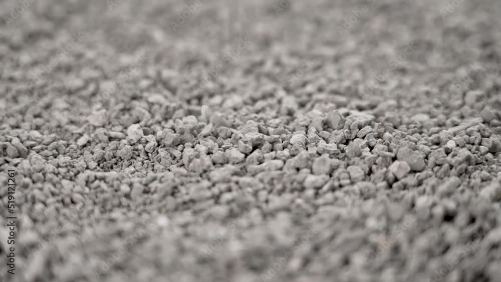 Cat tray filler made of bentonite. Falling particles of gray pet litter. Rotation. Slow motion Cat tray filler made of bentonite. Falling particles of gray pet litter. Rotation. Slow motion
