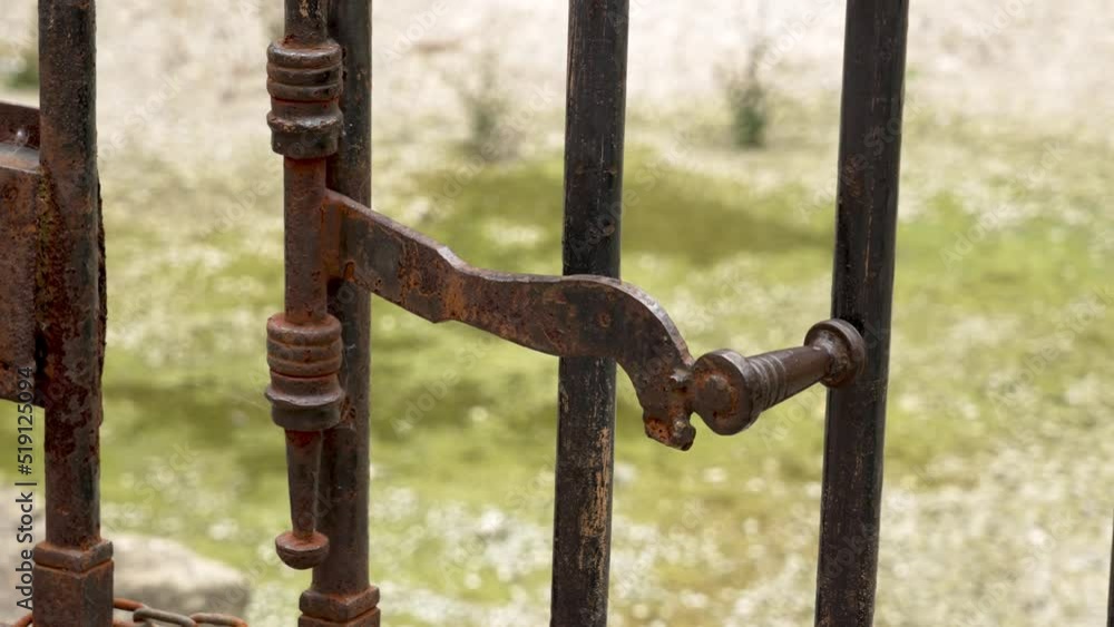 Ancient metal rusty wrought handle deadbolt of the door of the lattice gate of the antique cathedral in Spain closeup. Mechanical medieval latch Ancient metal rusty wrought handle deadbolt of the door of the lattice gate of the antique cathedral in Spain closeup. Mechanical medieval latch