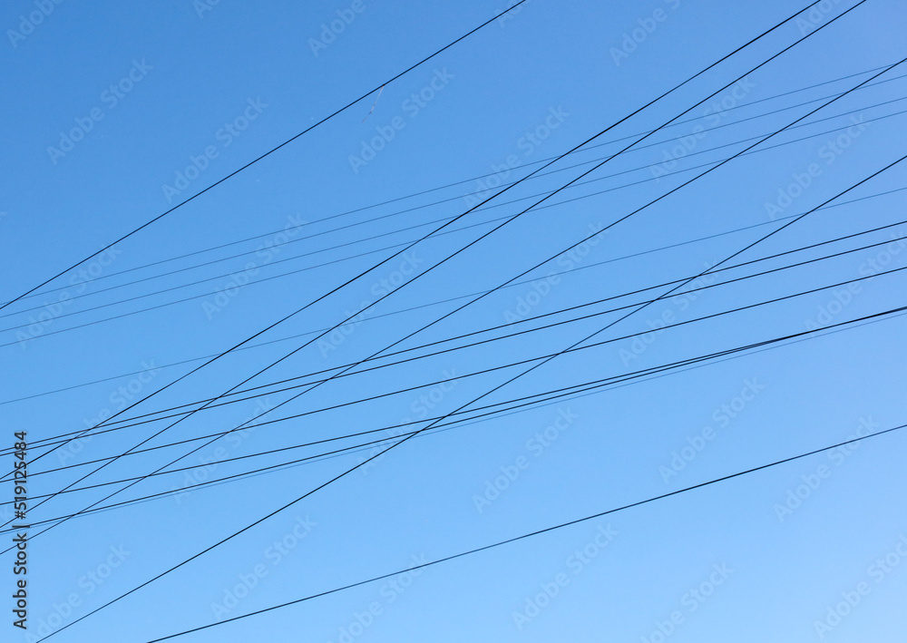 Electric wires against the blue sky. Background Electric wires against the blue sky. Background