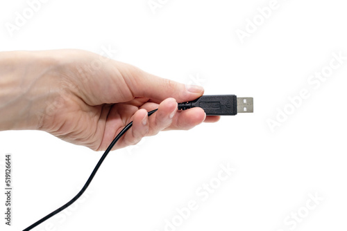 Black USB cable in hand on on a white background. Modern technologies in everyday life. Human hand holding usb cable. Cable for digital transmission of information