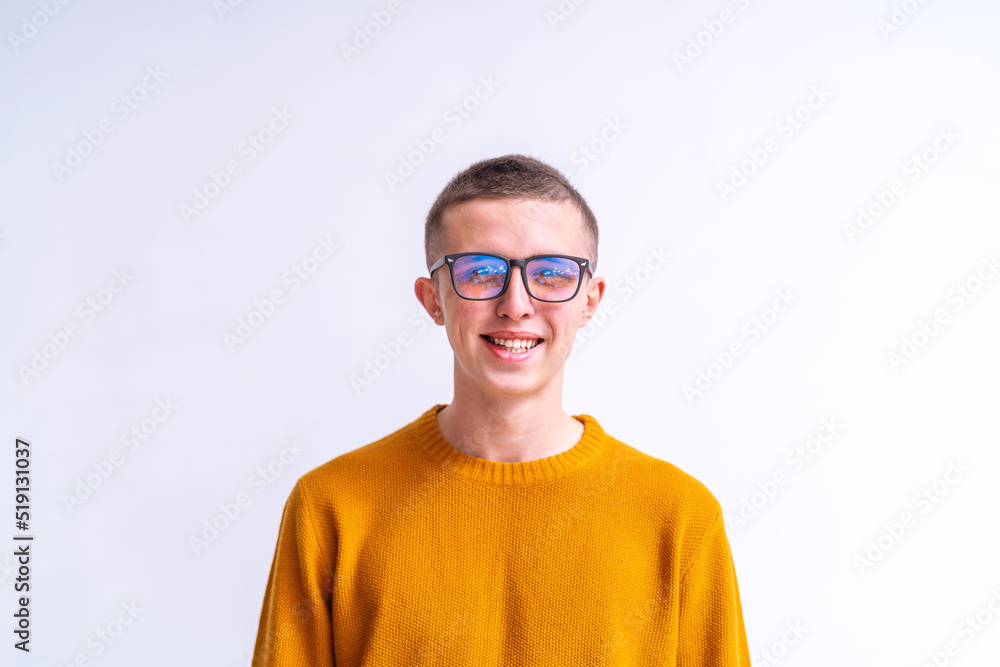 Portrait of a happy, handsome young man in glasses and a yellow sweater, smiling and laughing, looking amiably at the camera on a white background with a copy space on a white background Portrait of a happy, handsome young man in glasses and a yellow sweater, smiling and laughing, looking amiably at the camera on a white background with a copy space on a white background