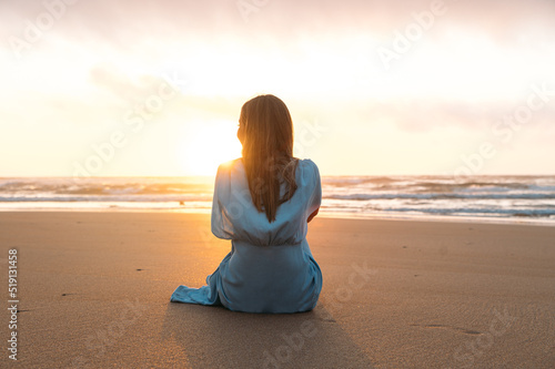 Unrecognizable woman admiring sea at sunset time
