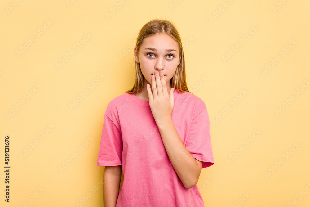 Young caucasian girl isolated on yellow background shocked, covering mouth with hands, anxious to discover something new. Young caucasian girl isolated on yellow background shocked, covering mouth with hands, anxious to discover something new.