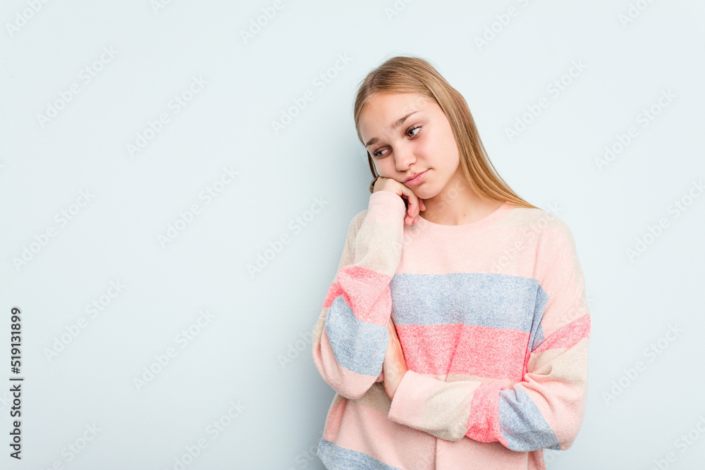 Young caucasian girl isolated on blue background who feels sad and pensive, looking at copy space. Young caucasian girl isolated on blue background who feels sad and pensive, looking at copy space.